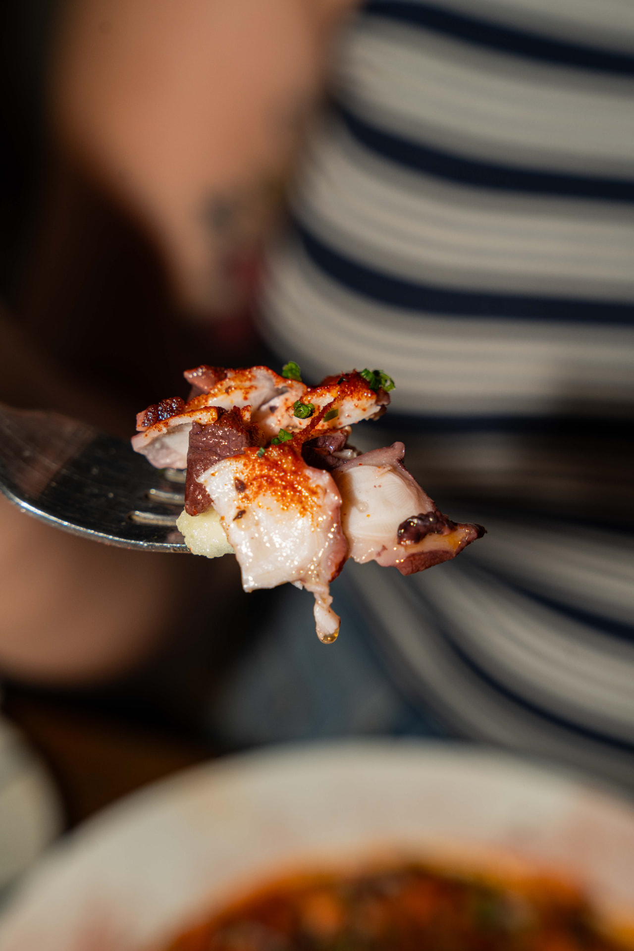 Forkful of grilled octopus with paprika
