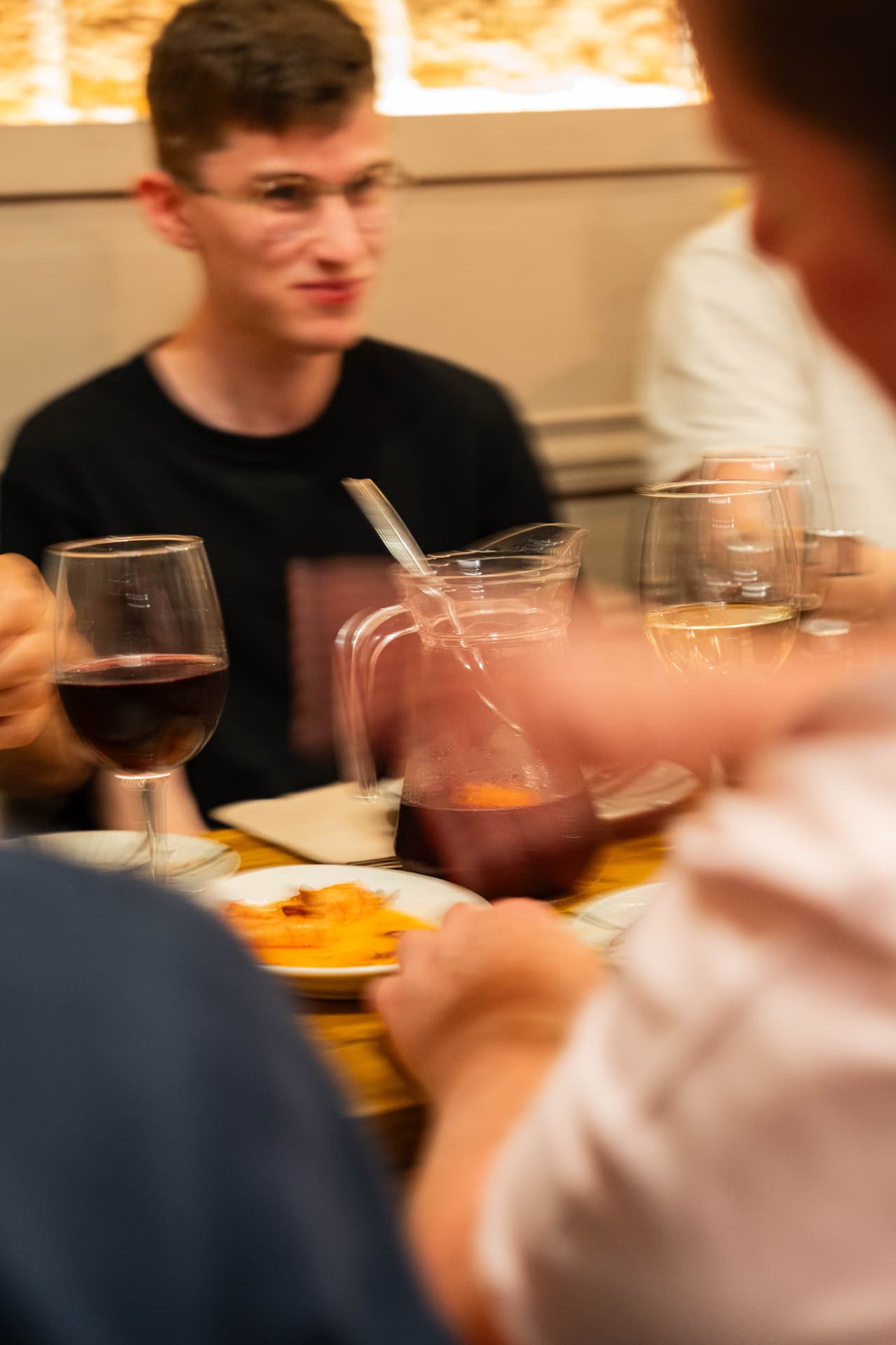 Friends sharing wine and sangria at a table inside Nix