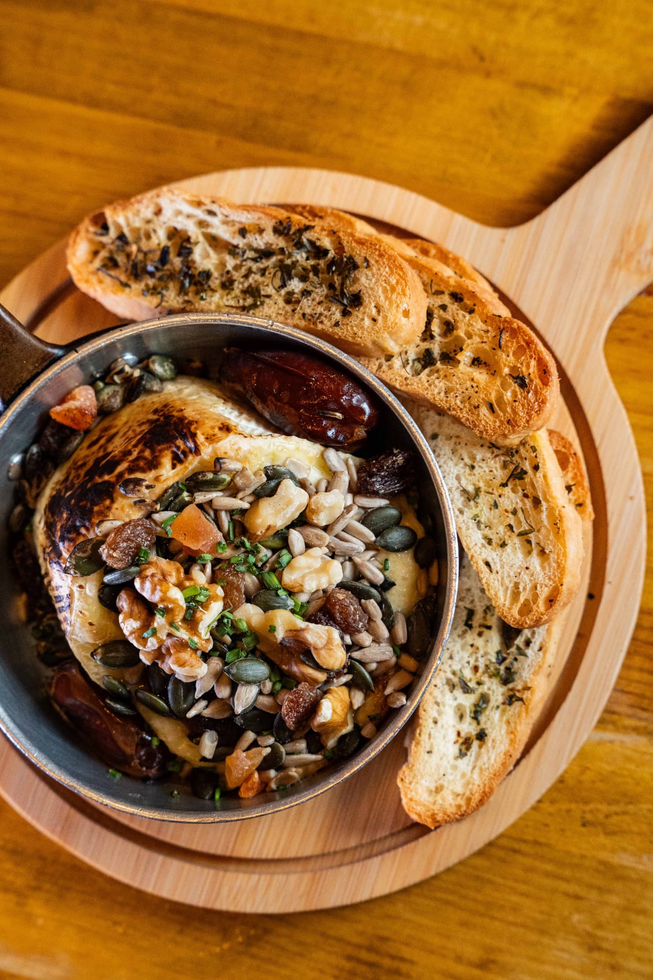 Baked camembert with nuts, dates and toasted bread